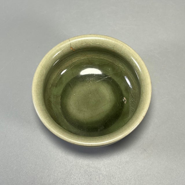 This antique Chinese Longquan celadon bowl has a rounded body and slightly flared rim. It is finished with rich olive-...