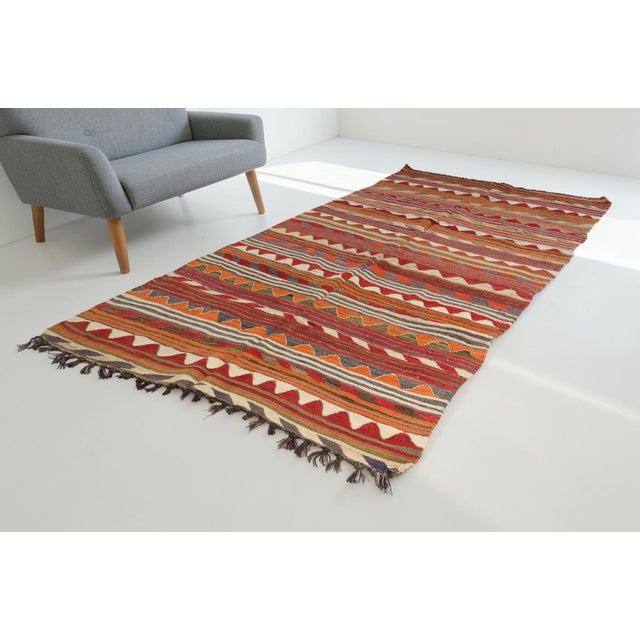 This is a vintage Turkish Oushak rug from the Mid 20th Century. The piece was hand-knotted.