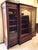 A bookcase/wardrobe dating to the turn of the 20th century, crafted in a late Historicist style with Neoclassical...