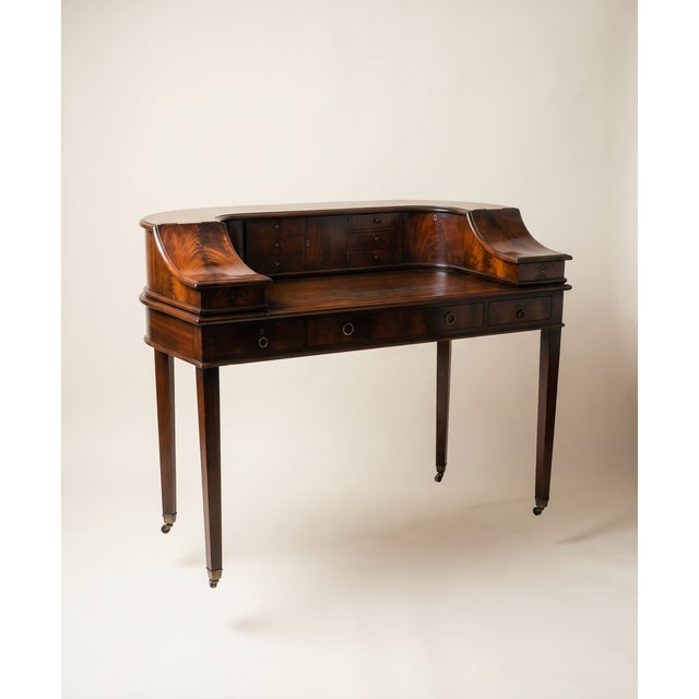 1920's "Carlton" Flame Mahogany Edwardian Writing Desk with Original Patina on Brass Casters. Brass hardware throughout....