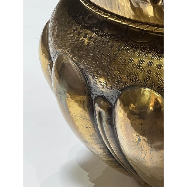 the large hand-hammered vessel with exaggerated everted neck above a tapering lobed body with diaper pattern at the shoulder