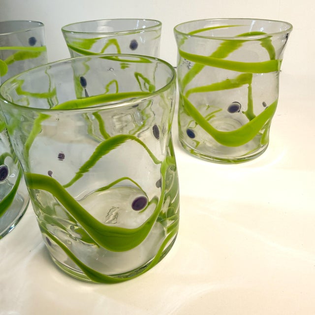 A vibrant 5‑piece set of hand‑blown tumblers from Peàn Doubulyu’s expressive Wavie line — studio glass created by partners...