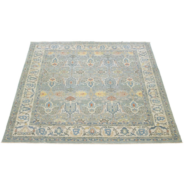 This square hand-knotted wool rug has a blue background adorned with multicolor accents all-over designs. This rug...