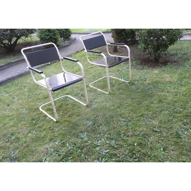 Pair of painted iron garden or patio cantilever chairs manufactured in the 1930s, Bauhaus design. The seats and backs are...