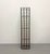 A sleek contemporary floor wine rack featuring a black metal frame with natural leather sling supports designed to cradle...