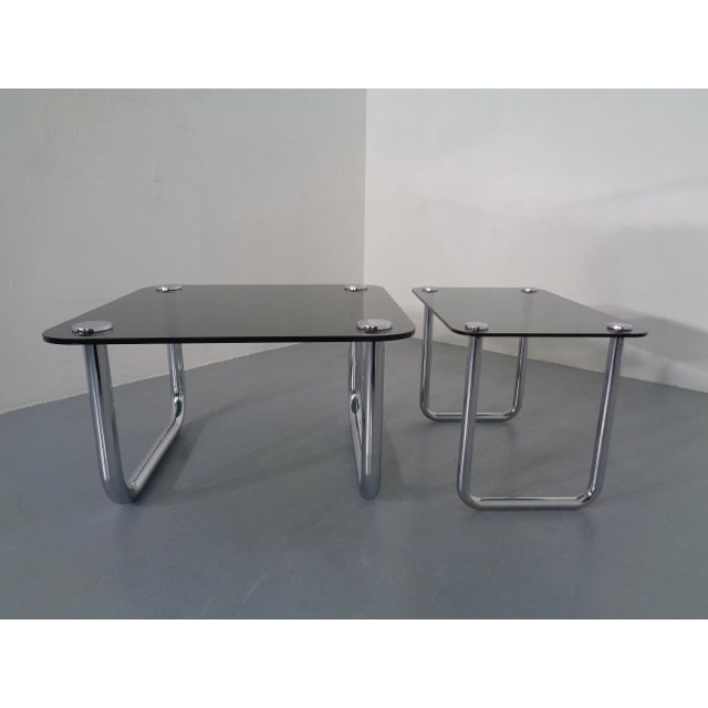 Italian side tables with smoke glass top and chrome-plated steel in the 1970s. Dimensions: Height 44/44 cm. Width 64/74...