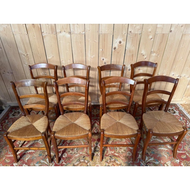 Set of eight French rustic-style dining chairs, 20th century, made of fruitwood with a warm patina. Ladder-back design...