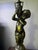 A beautifully detailed mid‑century brass lamp featuring a sculpted cherub standing atop a faceted cut‑glass base with a...