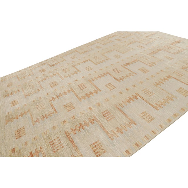 Hand-knotted in wool, this 9x12 Scandinavian rug features ivory and beige tones underscore geometric patterns in mainly...