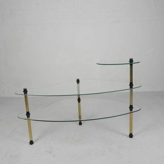 Three glass plates, 2 of which are kidney-shaped and 1 round, resting on 3 legs. The table can be dismantled completely....