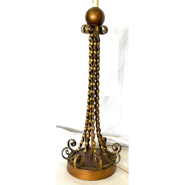 Very cool mid-century modern tall table lamp circa 1950's. It's made of twisted metal in a gold-bronze painted finish and...