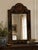 Elegant vintage Chinoiserie-style mirror featuring a black lacquered frame with hand-painted floral and botanical...