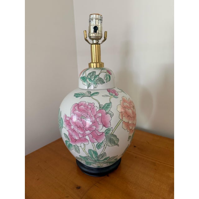 Vintage Chinoiserie ginger jar table lamp with pink and peach peonies on a white ground. Round black wooden base and...