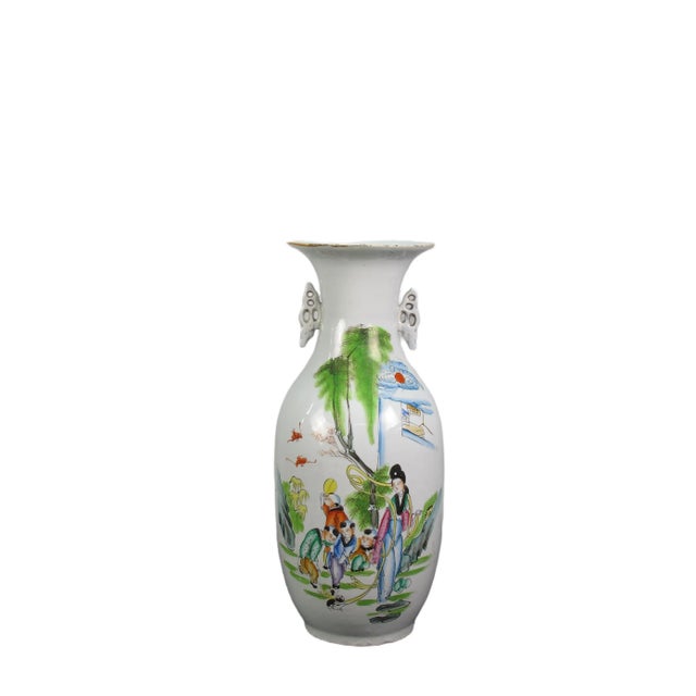This vintage Chinese Famille Rose porcelain vase is adorned by hand painted figures of women and children playing outside...