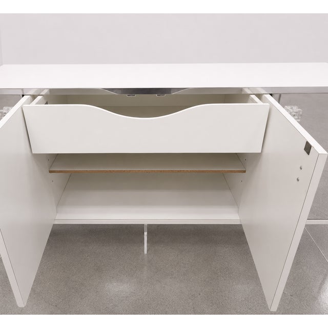 This vintage mirrored credenza has a great glam look with four mirrored cabinet doors, white laminate sides with lucite...