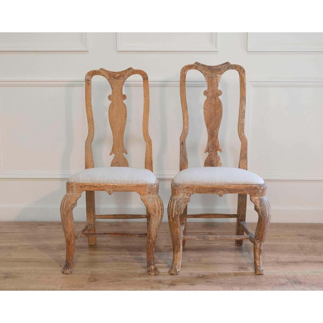 A genuine pair of period Rococo chairs dating to circa 1770, retaining traces of their original painted surfaces. The...