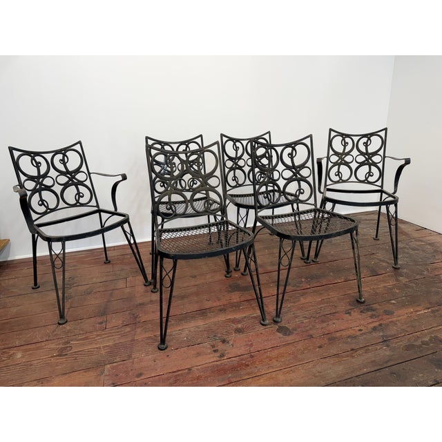 A very fine set of Woodard wrought iron patio chairs. Circa 1960. The backs of the chairs are the design focal point. The...