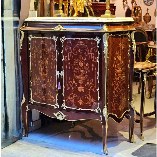 Bring timeless French elegance to your interior with this ornate Louis XV-style cabinet, crafted with a rich wood finish...
