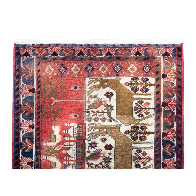 An incredible folky mid-20th century Persian Klederdasht pictorial rug depicting four large deer living amidst a field of...