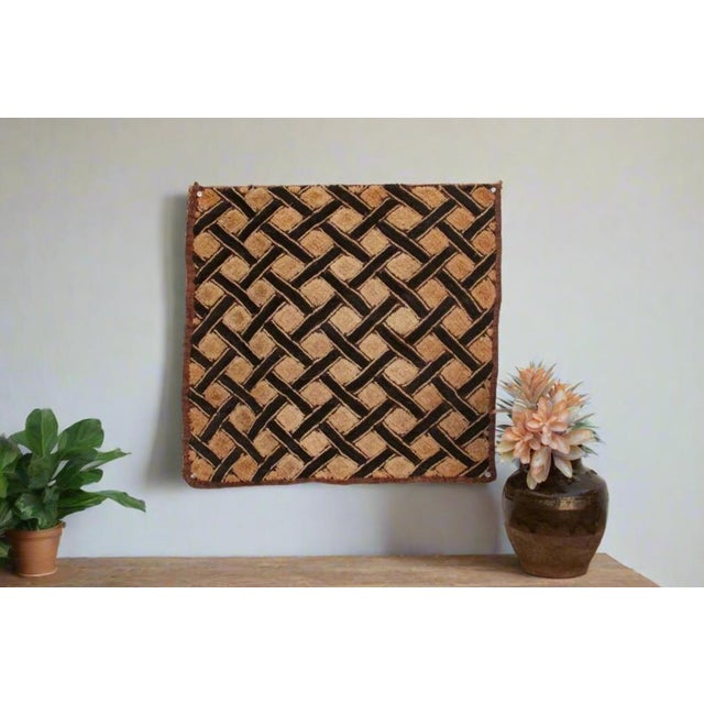 A captivating masterpiece of African textile art, this vintage Kuba cloth panel is a testament to the unparalleled...