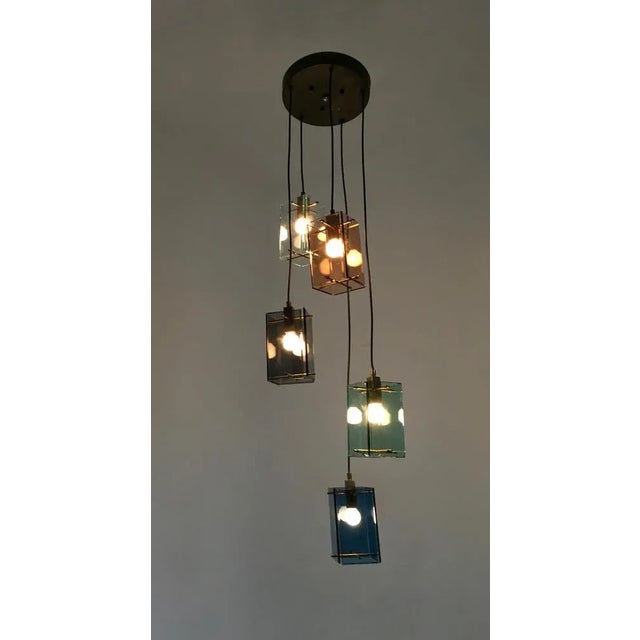 Made in Italy, 1960s. This ceiling light has bevelled glass diffusers held in place with brass supports, suspended from a...