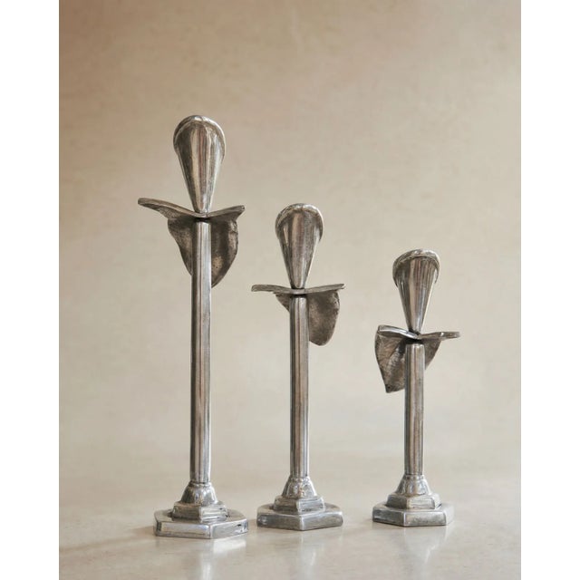 Bring sculptural elegance to your home with this striking set of three vintage pewter calla lily candleholders. Featuring...