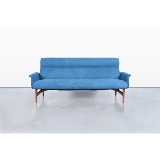 Introducing a stunning mid-century walnut sofa, meticulously crafted in the United States during the vibrant 1960s. This...
