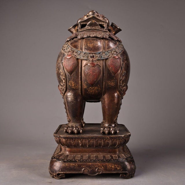 This impressive antique bronze censer features a guardian lion (Foo Dog) seated upon an integral pedestal base. The lion...