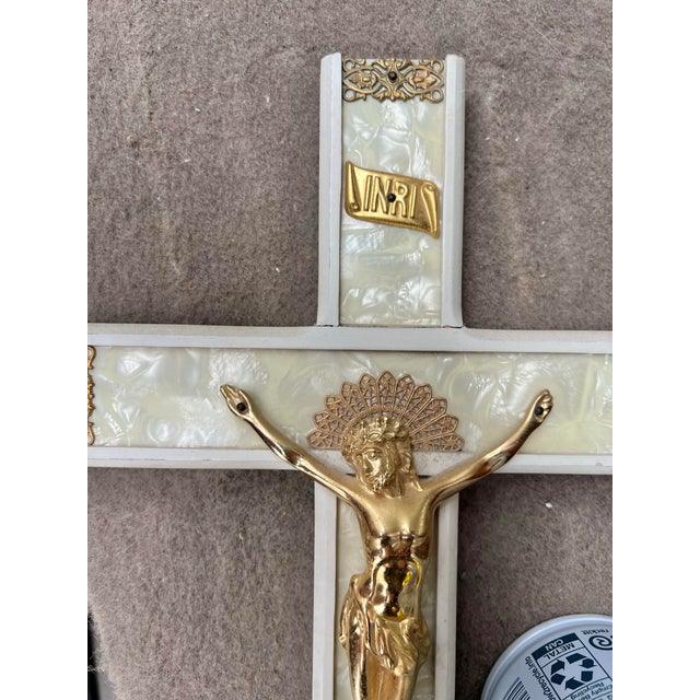 This is a vintage 1960s crucifix featuring a gold-colored metal corpus on a faux mother of pearl celluloid cross. The...