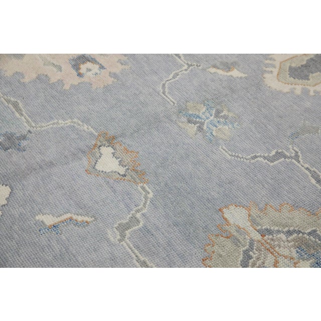 This modern Turkish Oushak rug is a stunning piece of art that has been handwoven using traditional techniques by skilled...