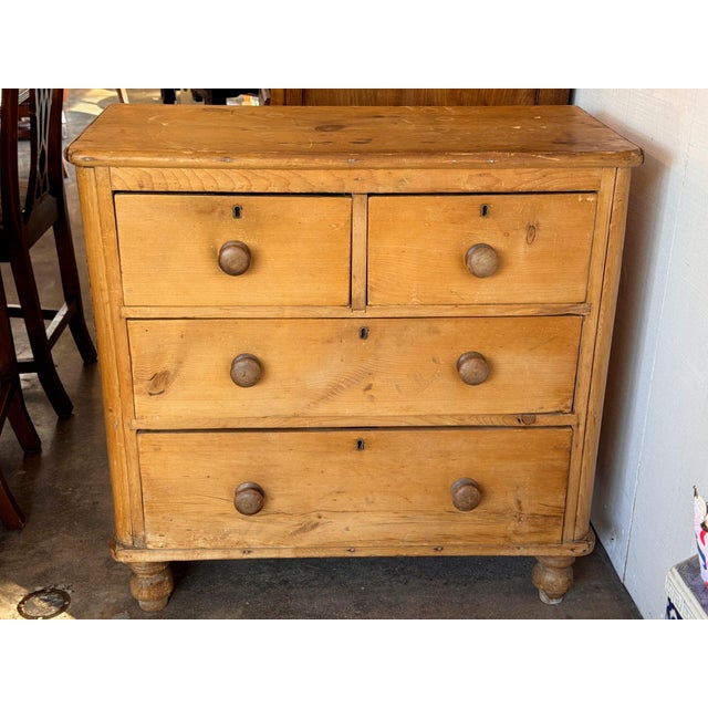 Two short drawers over two long ones, each with turned wood knobs, on a plain 19th century English case with turned feet....