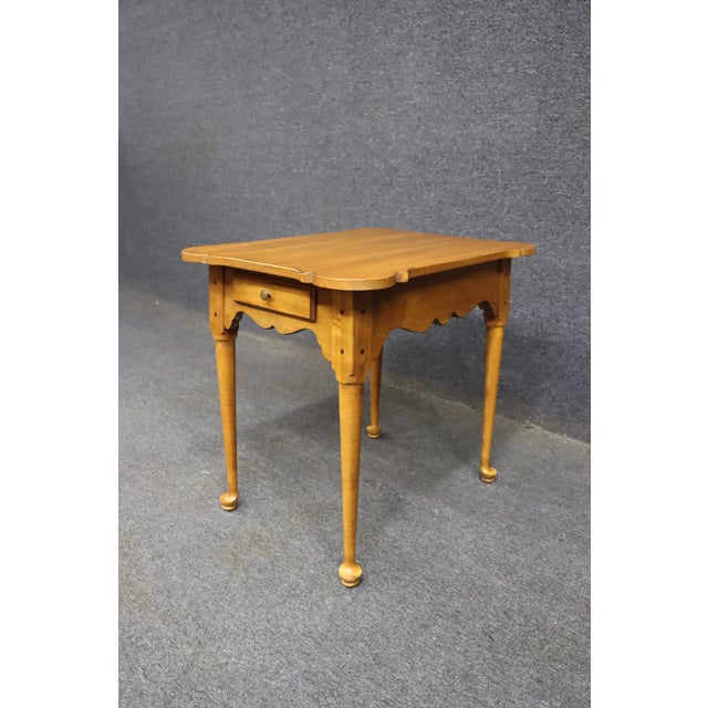 Ethan Allen maple side table with a shaped and scalloped top, single drawer, scalloped apron, and tapered legs with pad...