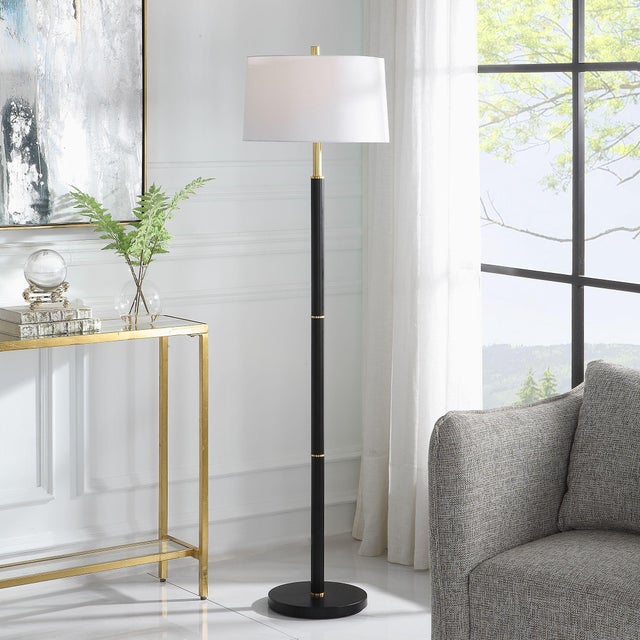 Simple in design, this black metal floor lamp is embellished with gold rings equally spaced along the length of the body....