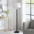 Simple in design, this black metal floor lamp is embellished with gold rings equally spaced along the length of the body....