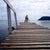 The image shows a cyclist on a wooden pier extending over the calm waters of Guanabara Bay. The cyclist, shirtless and...