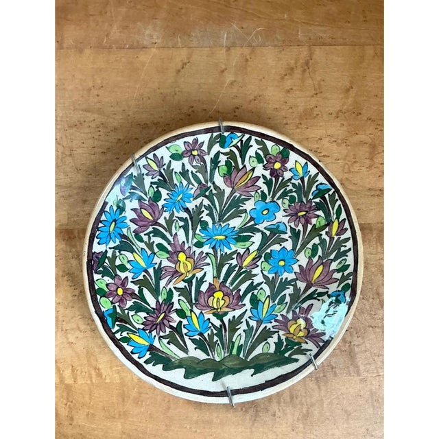 This vintage ceramic plate is densely hand-painted with an all-over floral pattern set against a creamy white ground....