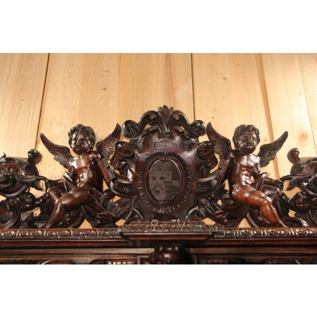 Important molded and richly carved walnut sideboard with console-shaped upper supports formed by chimeras, and a central...
