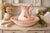 A charming vintage ceramic wash basin and pitcher set, finished in a soft peach-to-ivory gradient glaze with delicate...