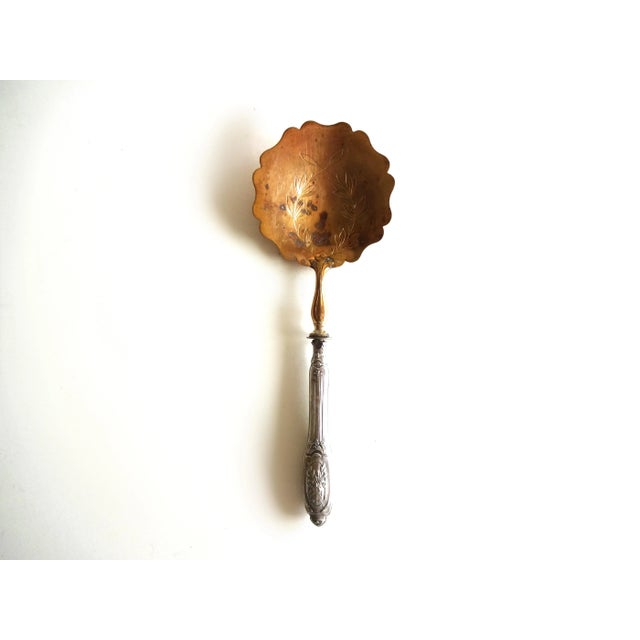 An antique French strawberry spoon. The handle is repoussé sterling silver in a rococo Louis XVI design: Minerva sterling...