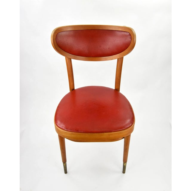 A pair of exceptional chairs, in completely original condition. Upholstered with artificial red leather, which is still in...