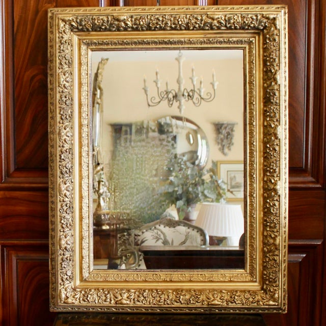 A beautifully ornamented ca. 1900 wall mirror with lots of detail rendered in gold leafed gessoed composition. The frame...