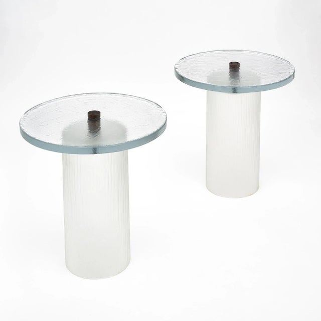 Pair of Murano glass tables, made of thick clear textured and molded glass. The top is connected to the base with a solid...