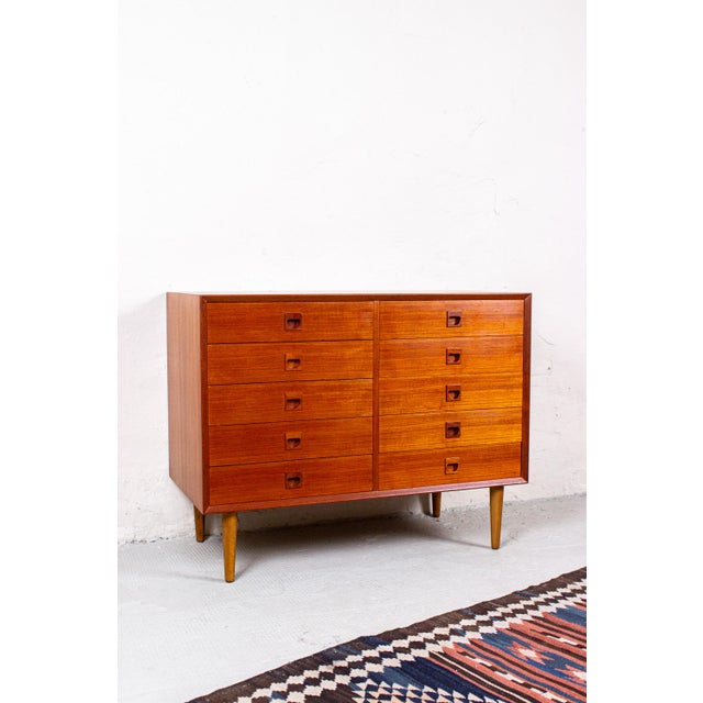 This high-quality chest of drawers from the Danish furniture manufacturer Erik Brouer stands out with its warm teak tone...