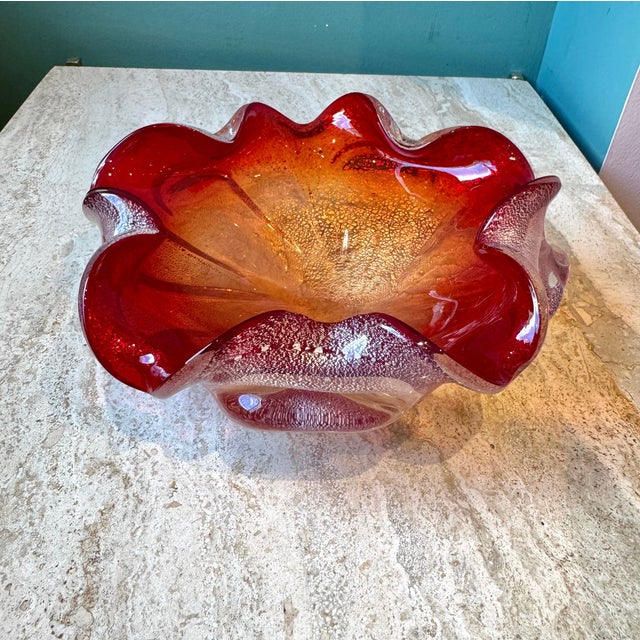 A spectacular large chunky hand blown Murano glass style bowl with a deep red color and silver leaf flecks running...