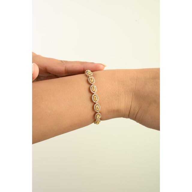 This luxurious tennis bracelet features 19 oval cut natural yellow sapphires totaling 5.76 carats, set in rich 14K yellow...