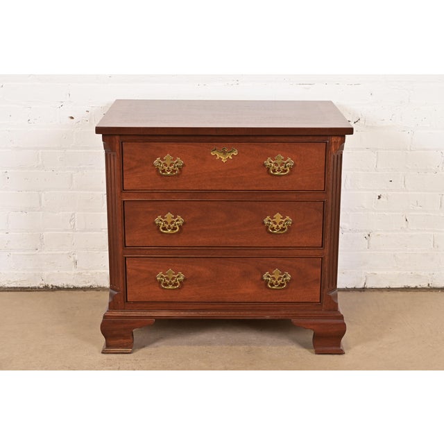 A beautiful Georgian or Chippendale style nightstand or bachelor chest of drawers By Baker Furniture USA, Circa 1980s...