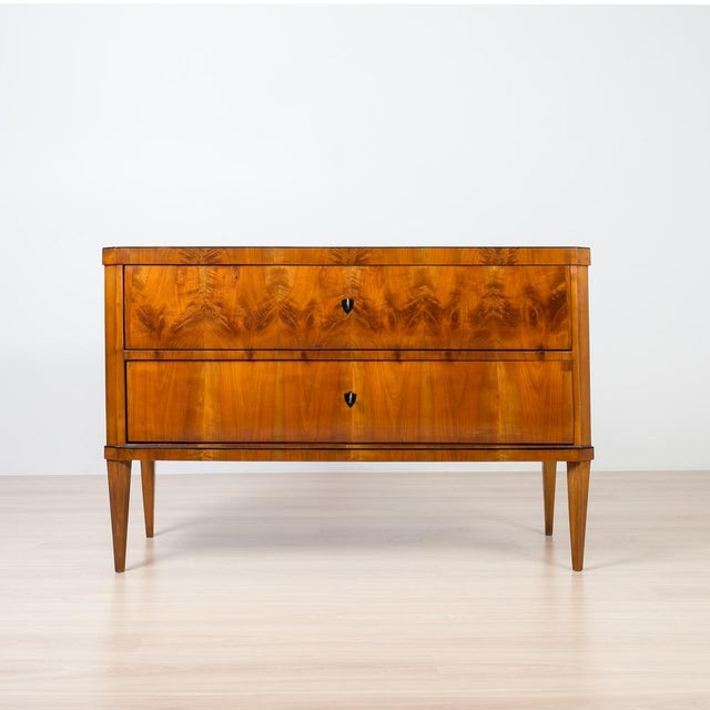 An elegant Biedermeier commode crafted in Germany circa 1830–1840, veneered in beautifully figured cherrywood. The front...