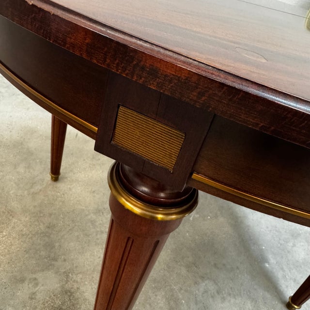 Louis XVI style mahogany round table with integrated extension. Louis XVI style mahogany round table with gilt inlay. with...