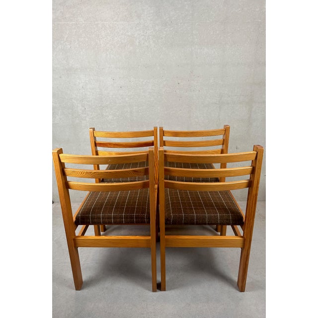 A set of 4 vintage pine dining room chairs. Fabric seat. German manufacturer. Sturdy structure. Labeled at the bottom of...