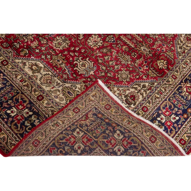 Beautiful vintage Persian Tabriz hand-knotted wool rug with a brown color field. This piece has a navy blue frame and...